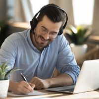 male studying online with headphones and laptop, oxford tefl celta online